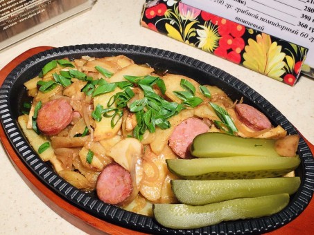 Гаряча сковородочка зі смаженою картоплею і підкопченими ковбасками